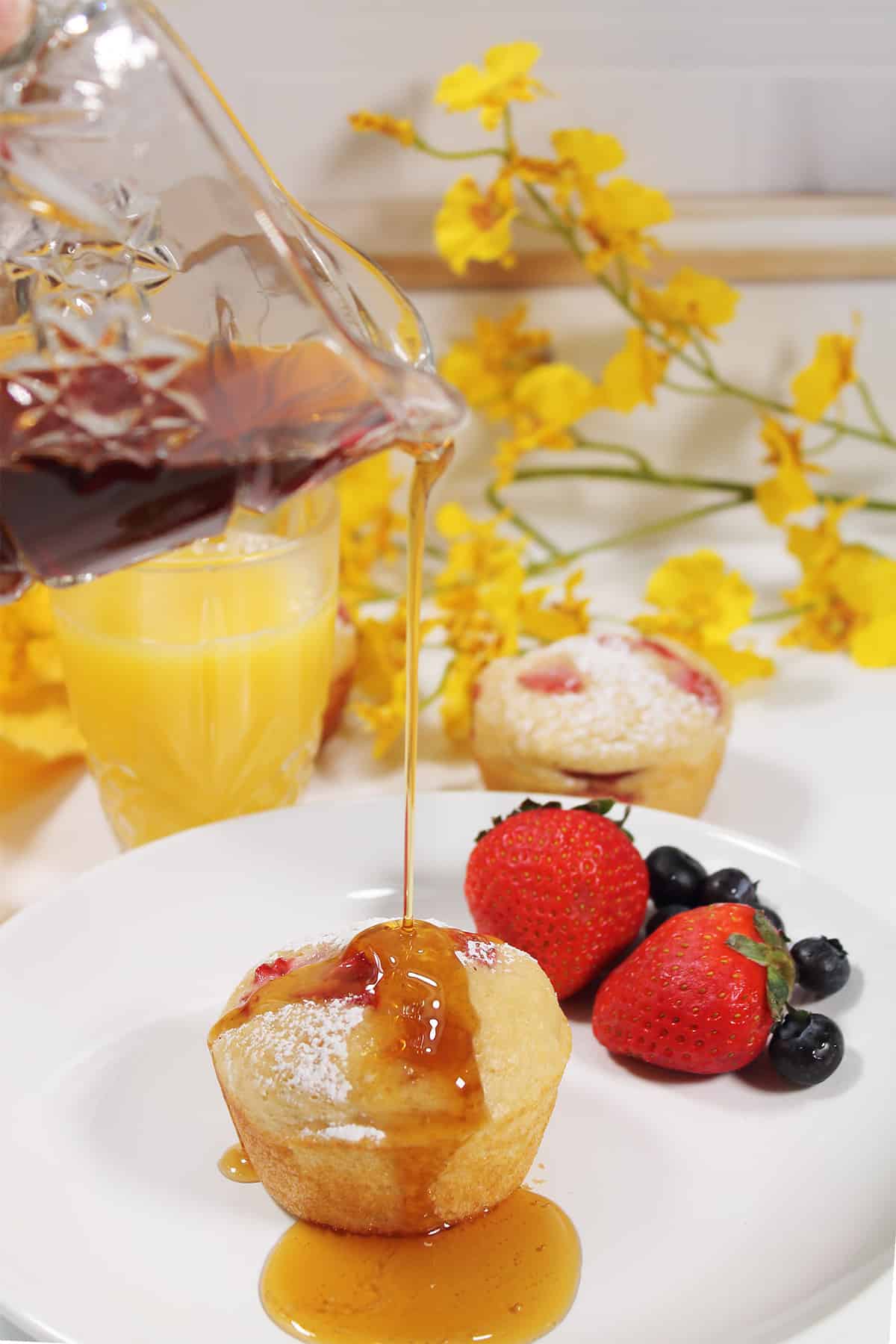 Drizzling maple syrup over muffin.