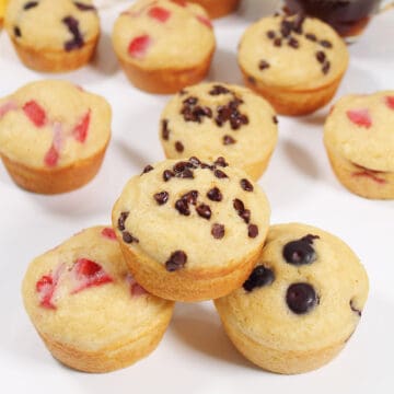 Stacked muffins with chocolate chips, blueberries and strawberries in them.