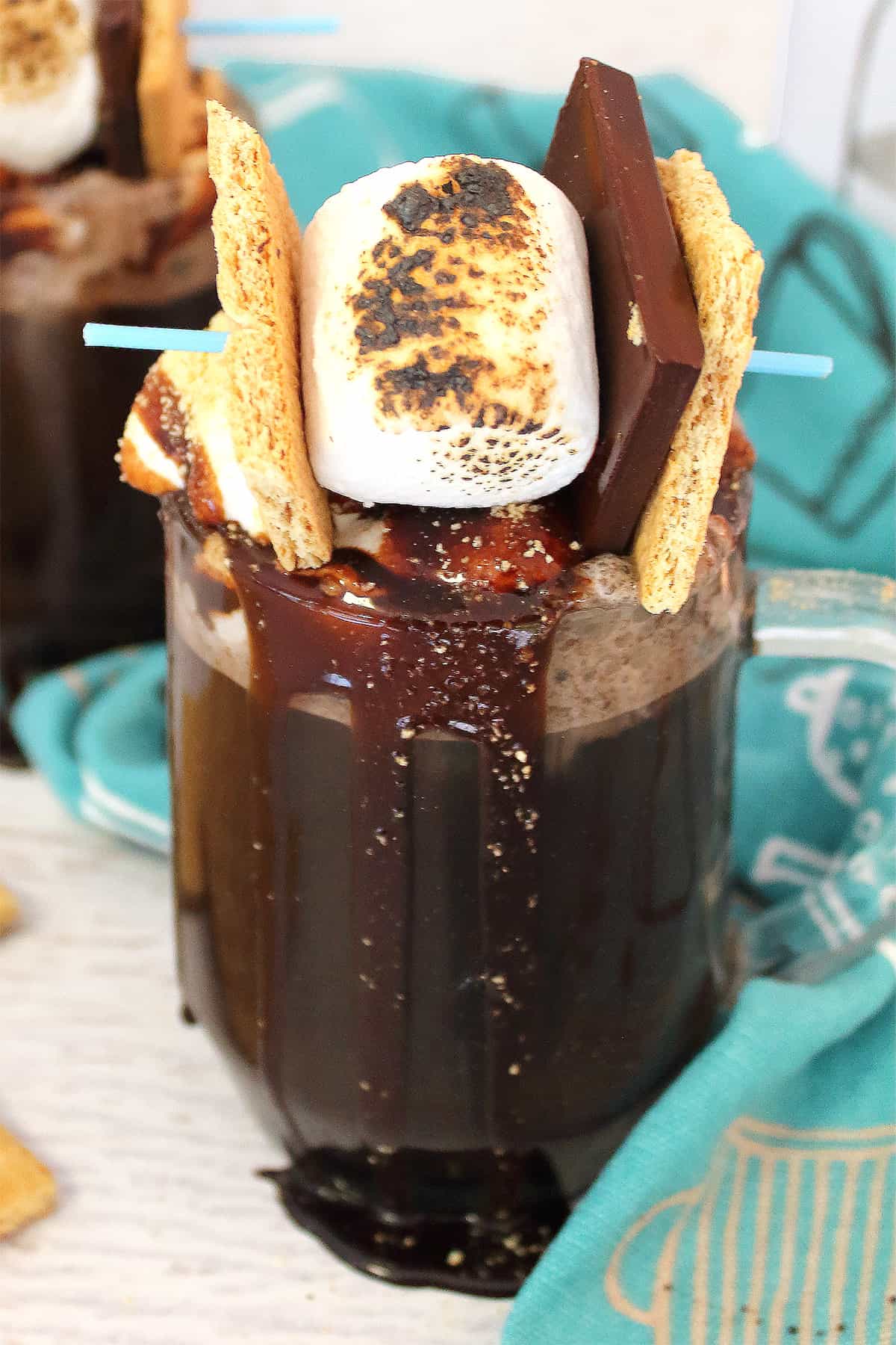 Closeup of coffee with marshmallow garnished with s'more.