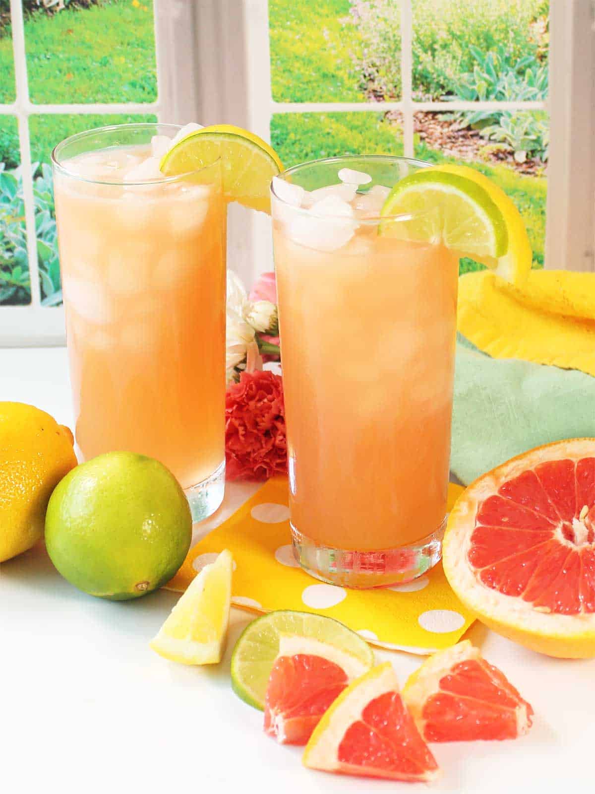 Two grapefruit tequila cocktails garnished with lemon and lime slice.