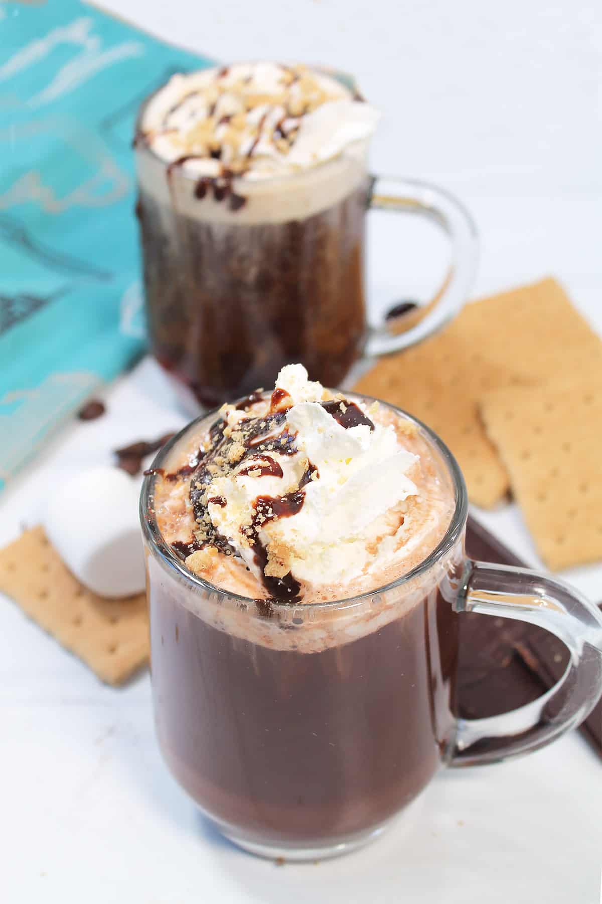 Two garnished smores coffees among graham crackers.