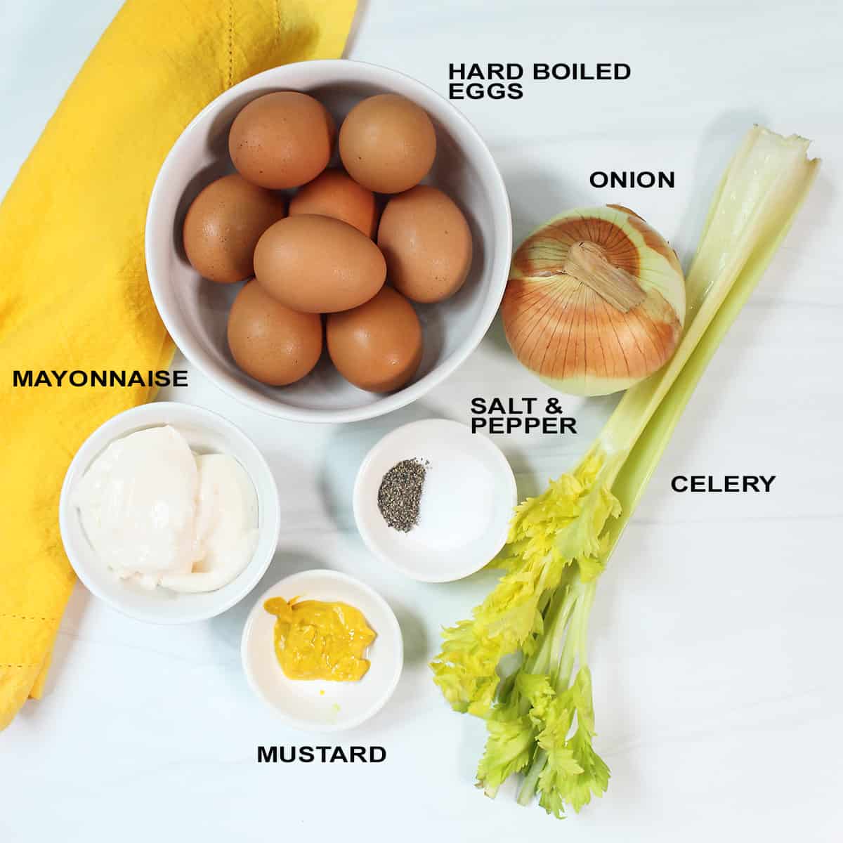Ingredients for egg salad on white table.