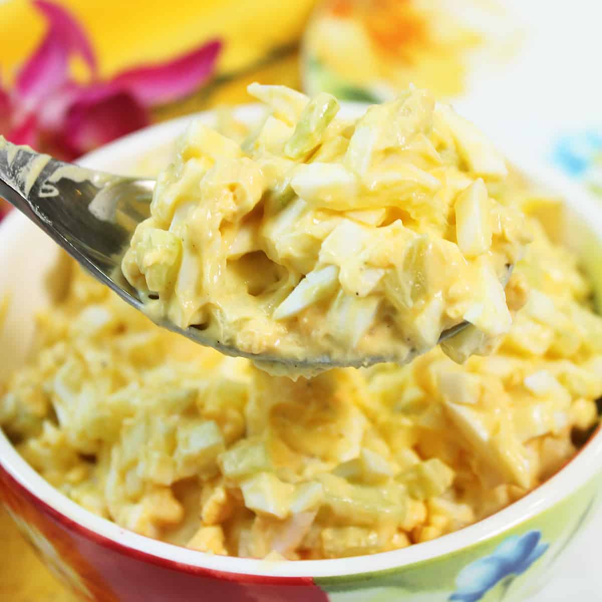 Spoonful of salad over bowl.