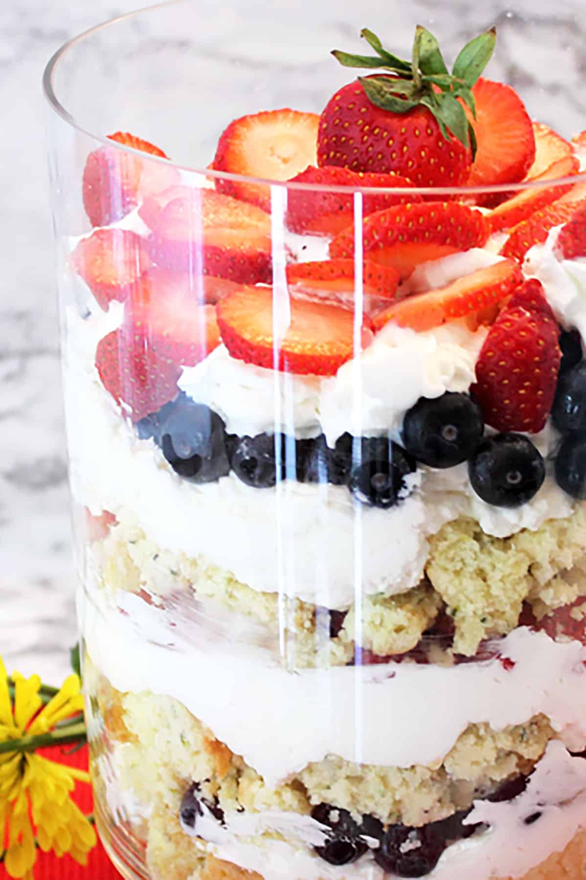 Trifle closeup showing layers of cake, cream and berries.