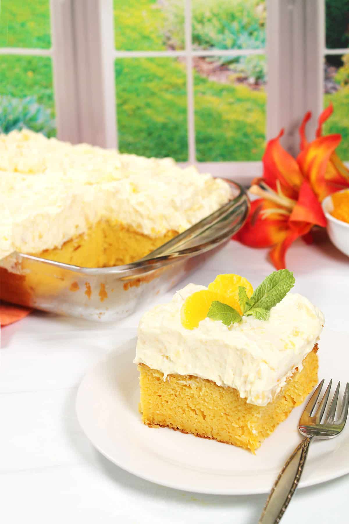 A slice of Mandarin Orange Cake in front of whole cake.