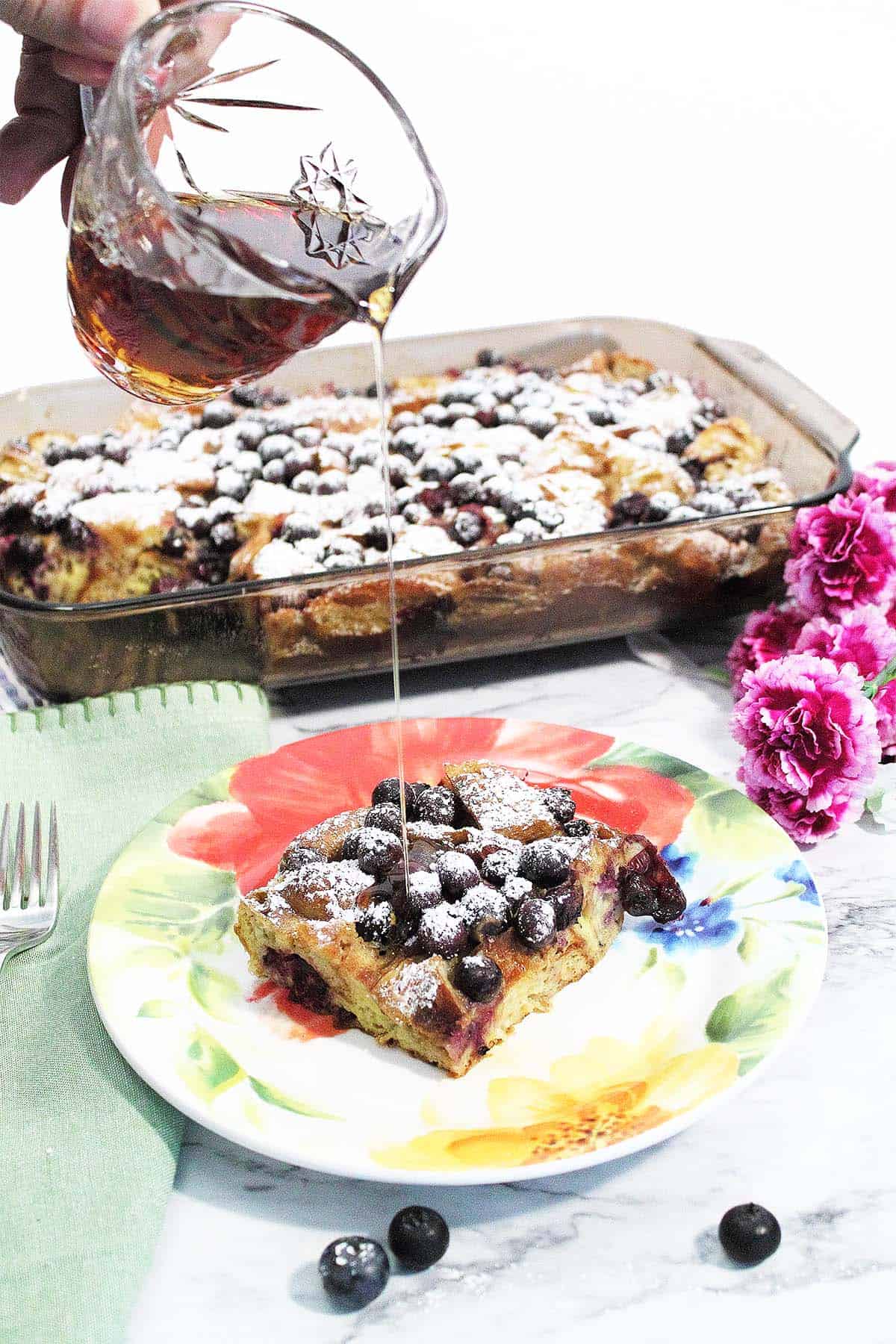 Pouring syrup on french toast .