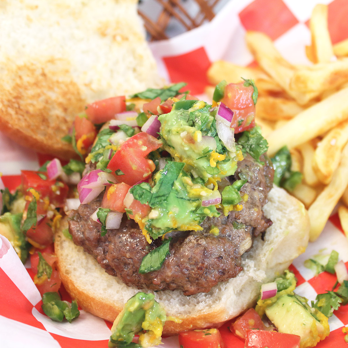 Overhead of surf and turf burger with salsa and fries.
