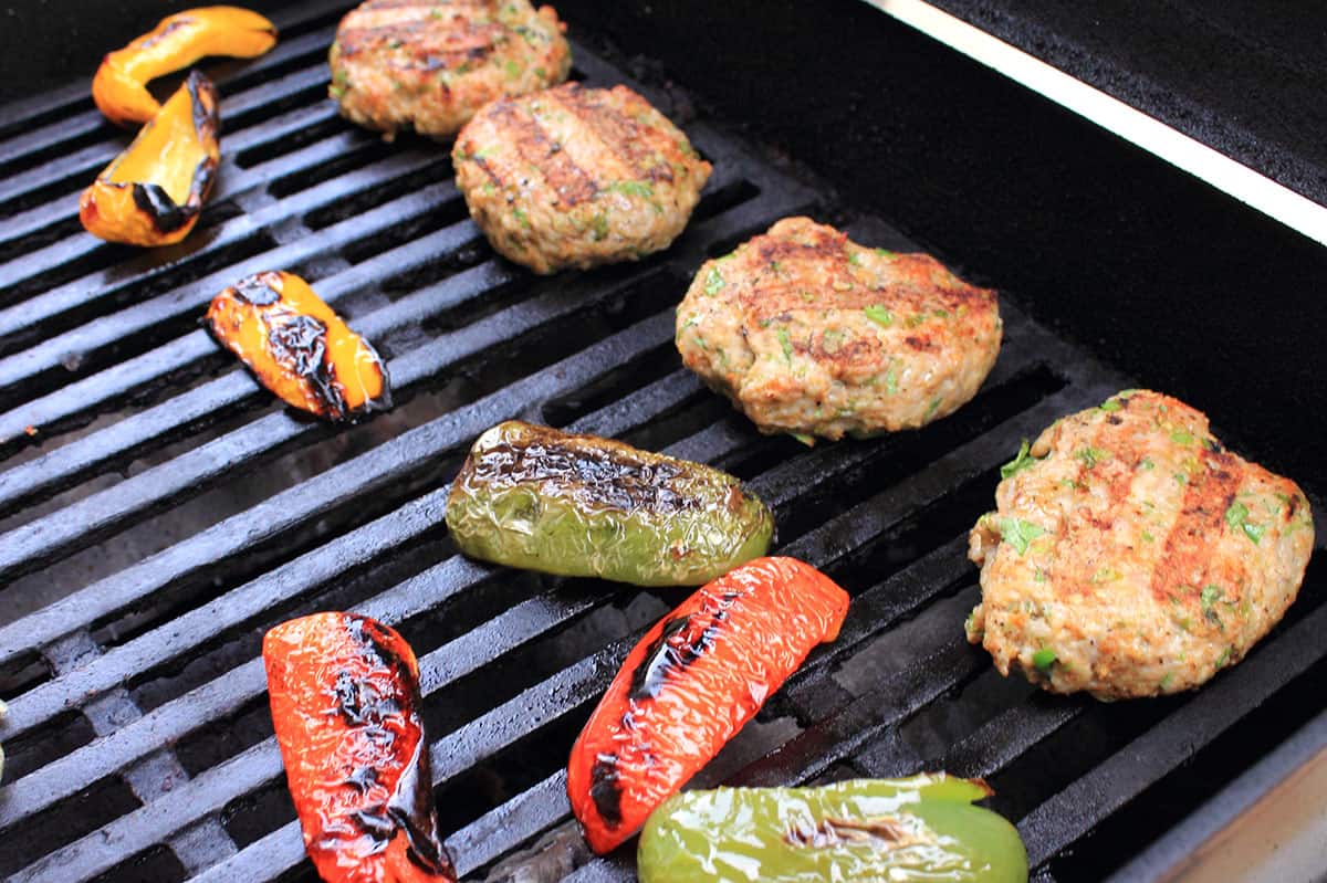 Gurgers peppers and onions on the grill.
