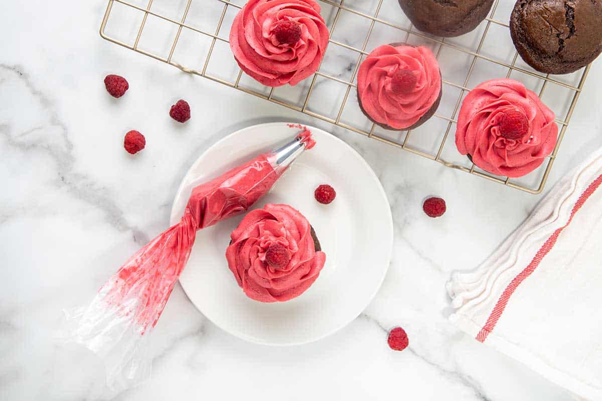 Frosting the cooled cupcakes.