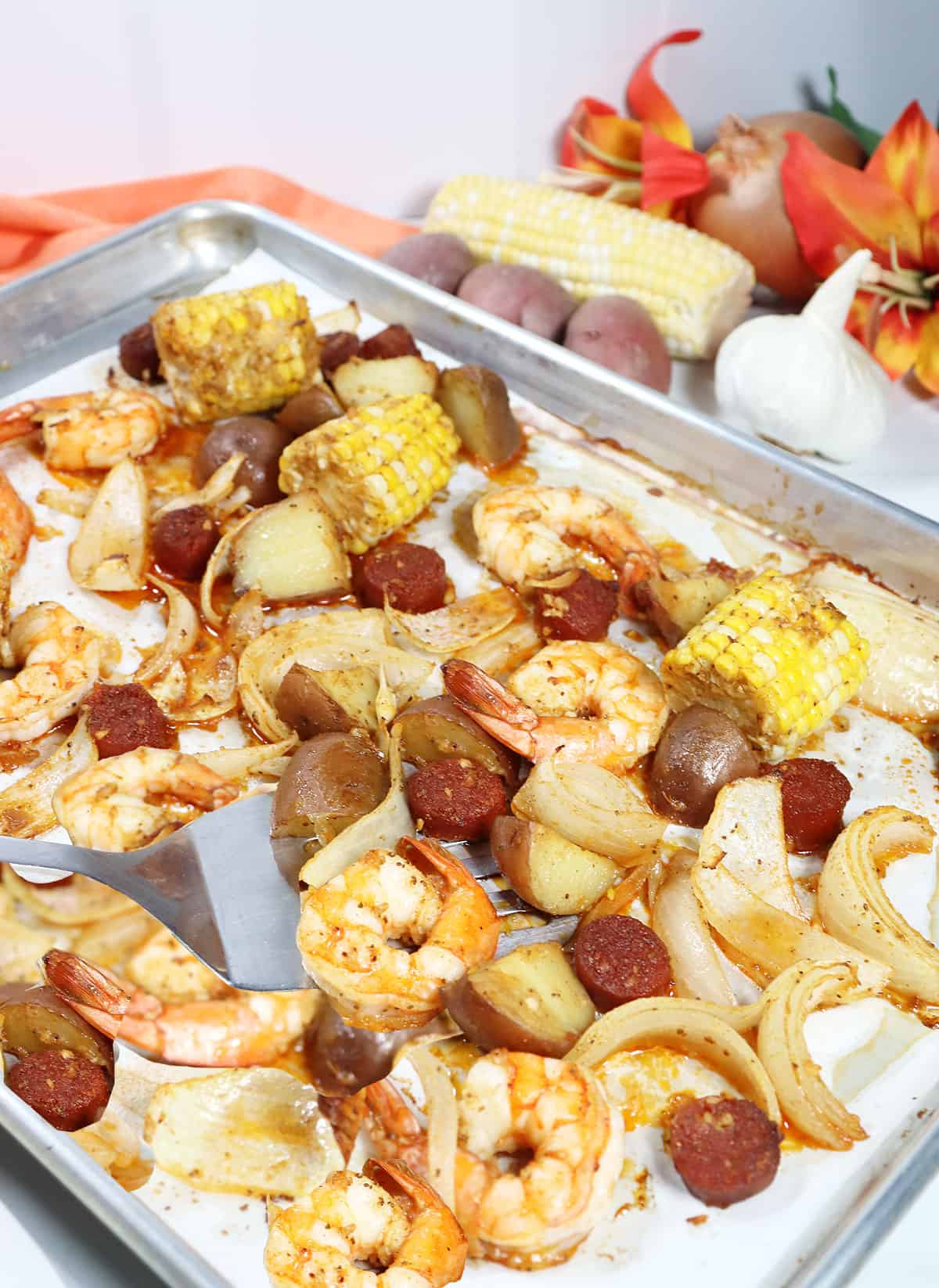 Spatula digging into the Sheet Pan Shrimp Boil Dinner.