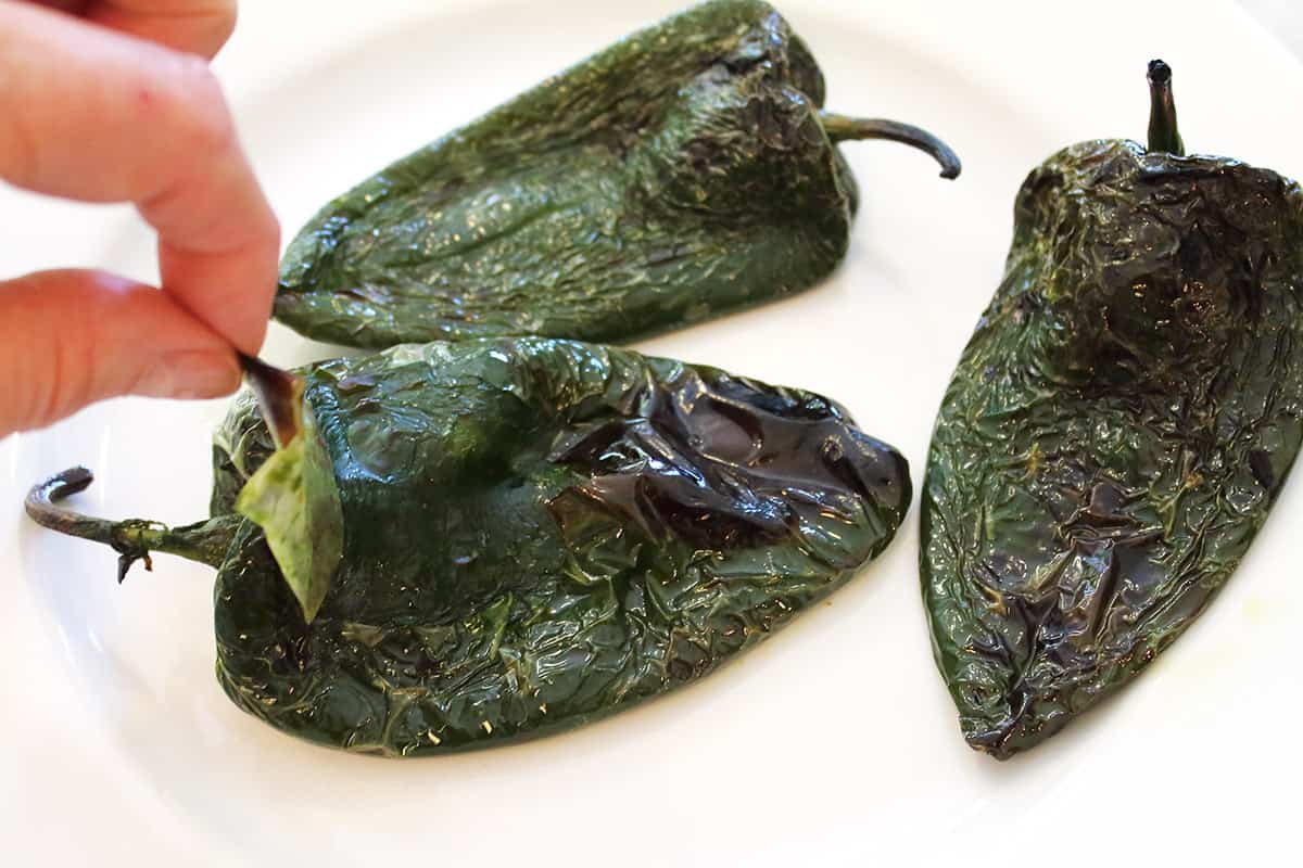 Peeling off the charred skin of the poblanos.