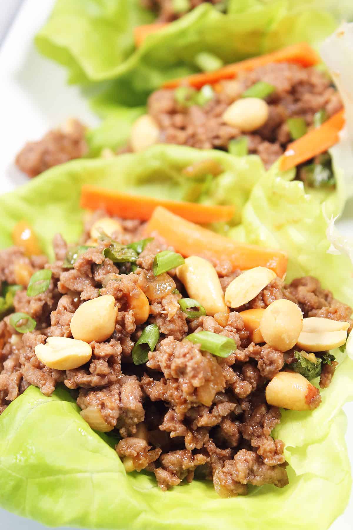 Closeup of garnished Thai beef lettuce wraps.