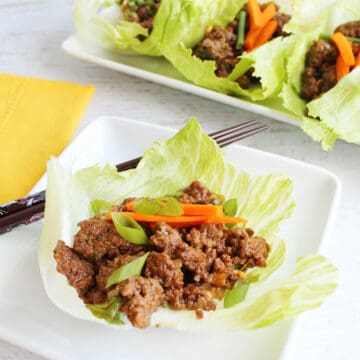 Serving of a lettuce wrap with platter in back.