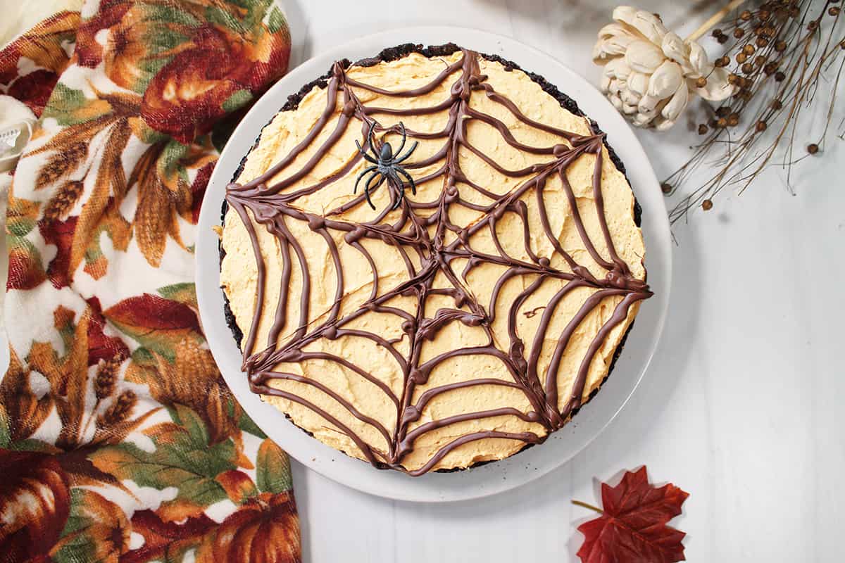 Spider web design on pumpkin cheesecake.