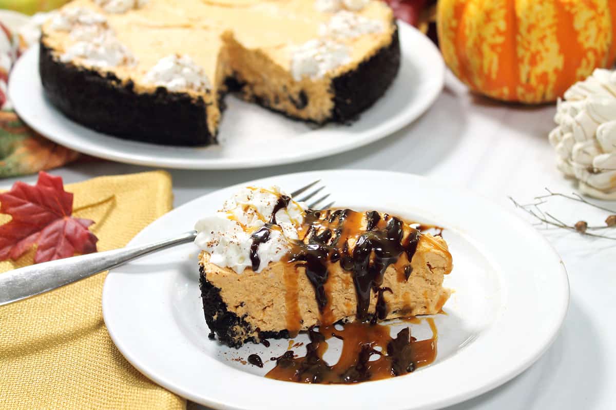 Slice of cheesecake with drizzles of chocolate and caramel.
