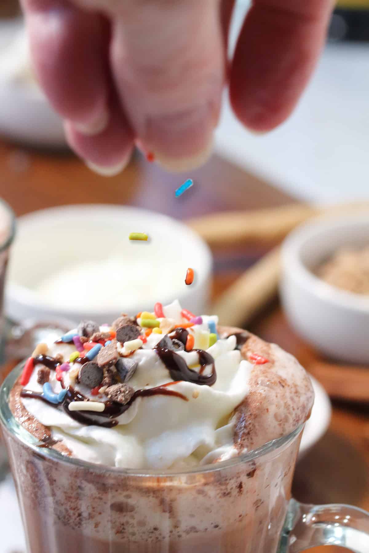 Sprinkling on sprinkles on top of whipped cream.