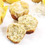 Closeup of halved muffin on white table.