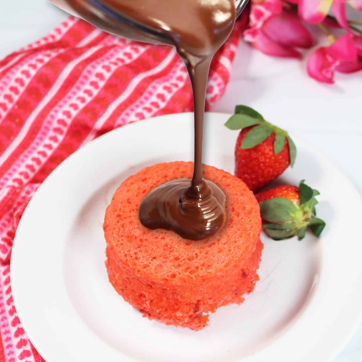 Pouring ganache over plated mug cake.