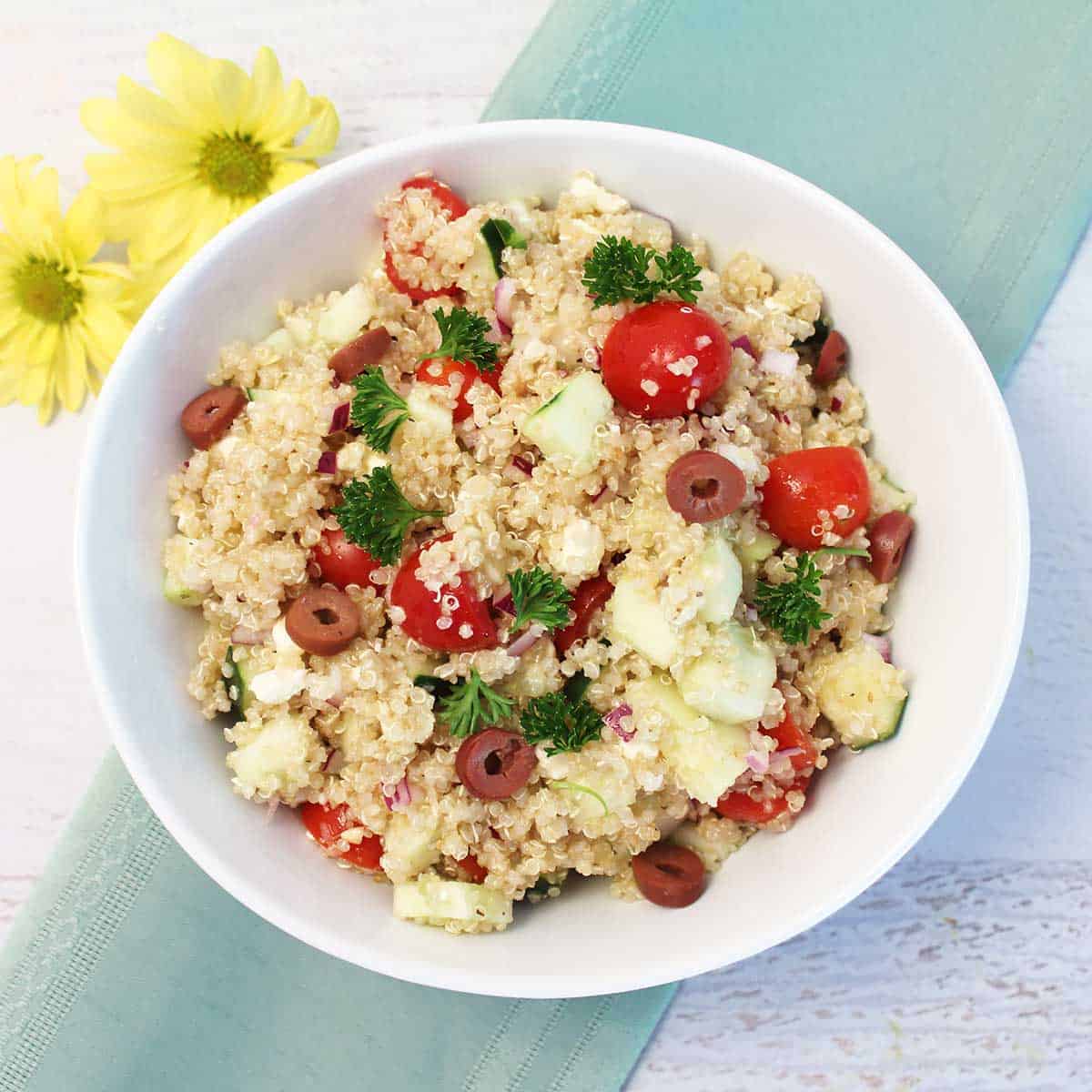 Overhead of cold quinoa salad in white serving bowl.