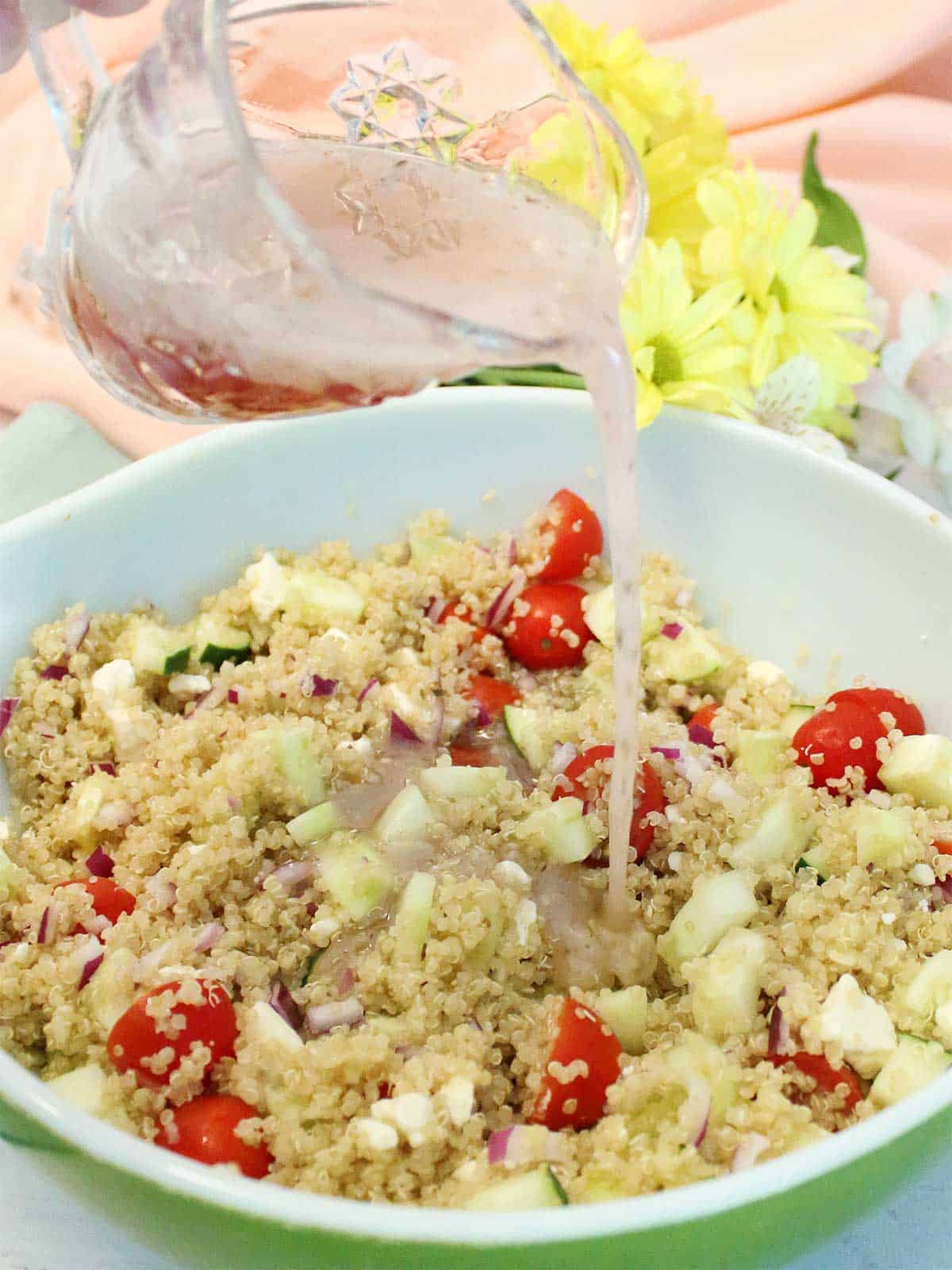Pouring dressing over quinoa salad.