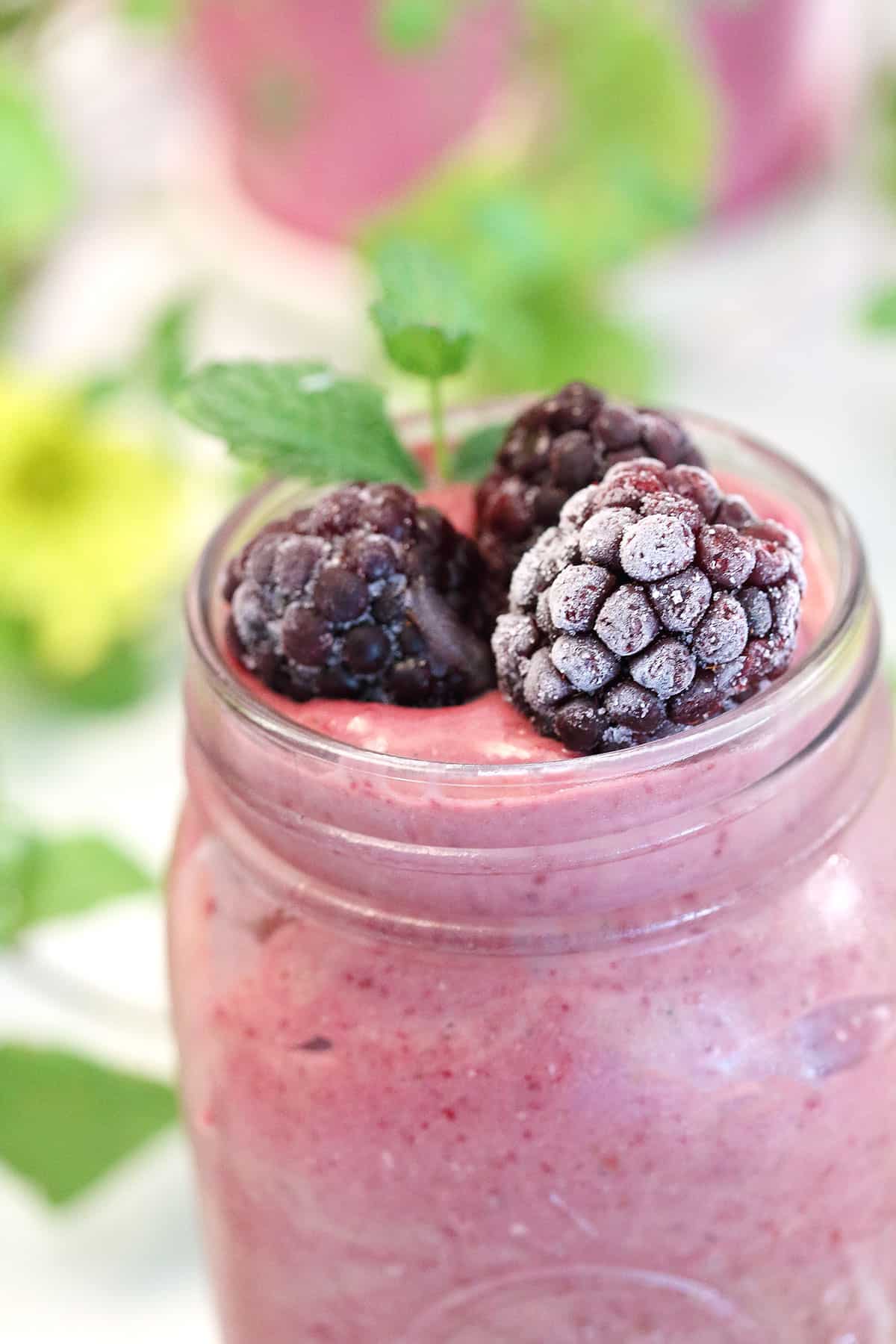 Closeup of creamy smoothie with blackberries and mint.