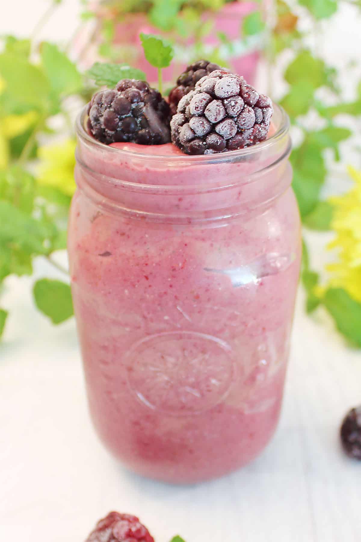 Blackberry Smoothie in mason jar topped with blackberries.