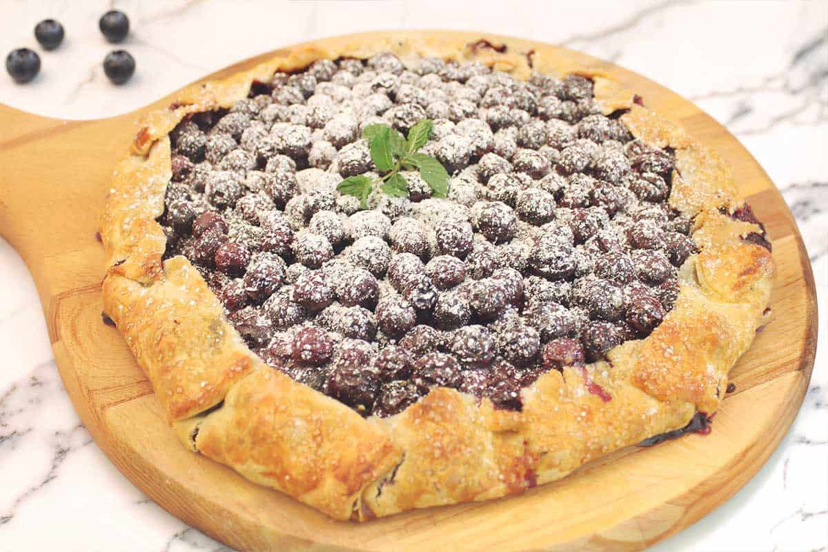 Garnished galette with powdered sugar, lemon zest and mint leaves.
