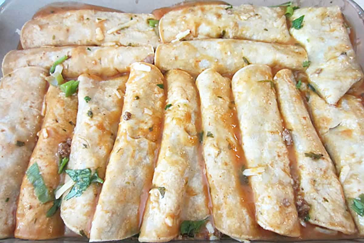 Rolled enchiladas in baking dish.