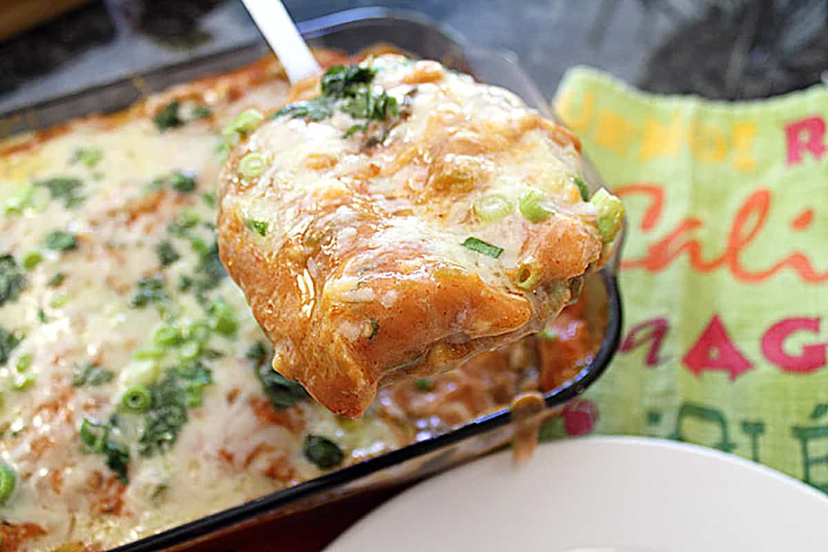Taking a serving on spatula out of hot casserole.