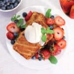 Overhead of topped grilled cake with ice cream, berries and mint.