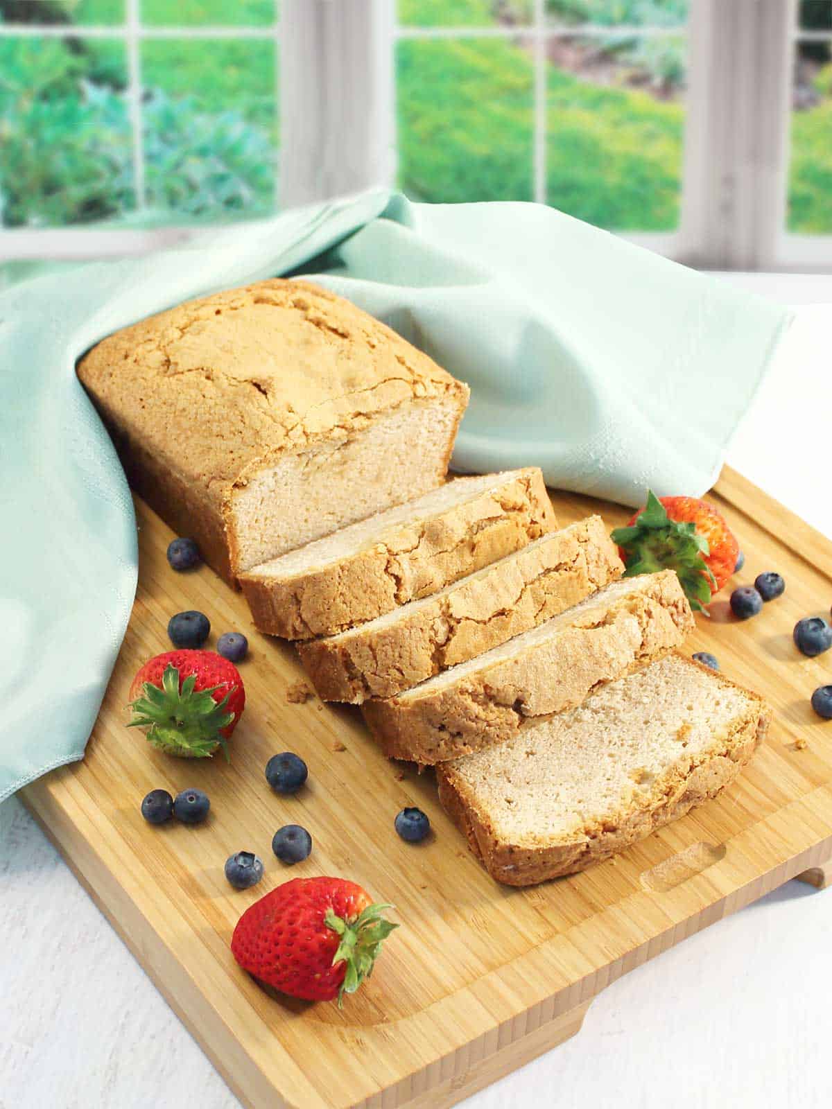 Pound cake sliced on wooden board.