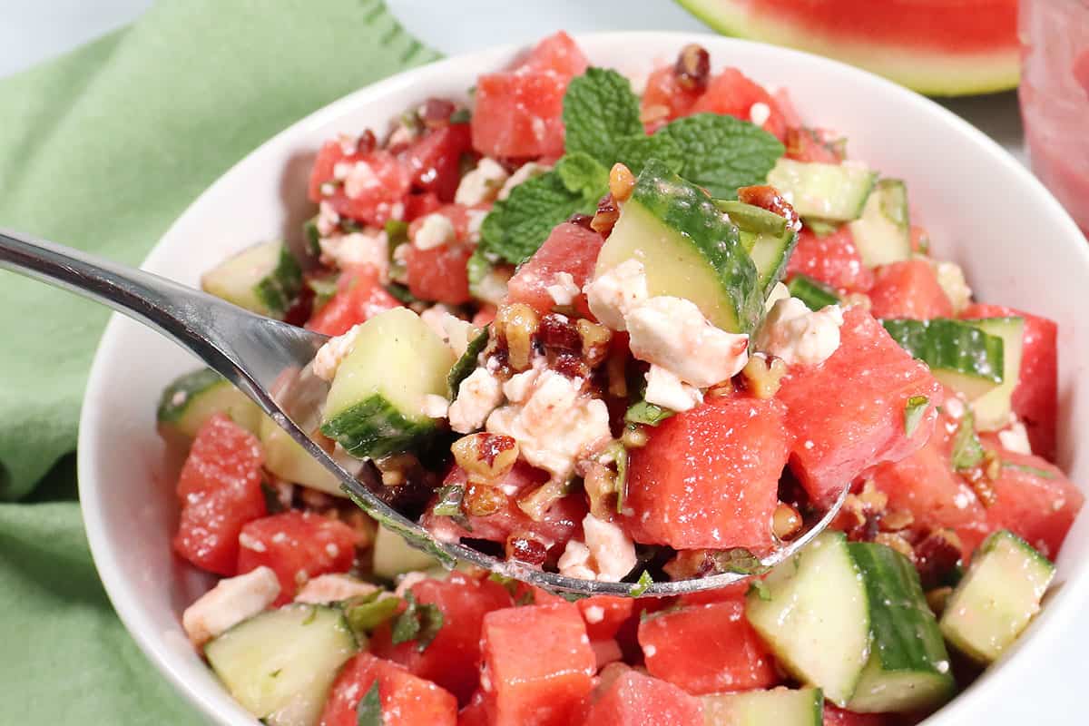 Spoonful of watermelon salad on serving spoon.
