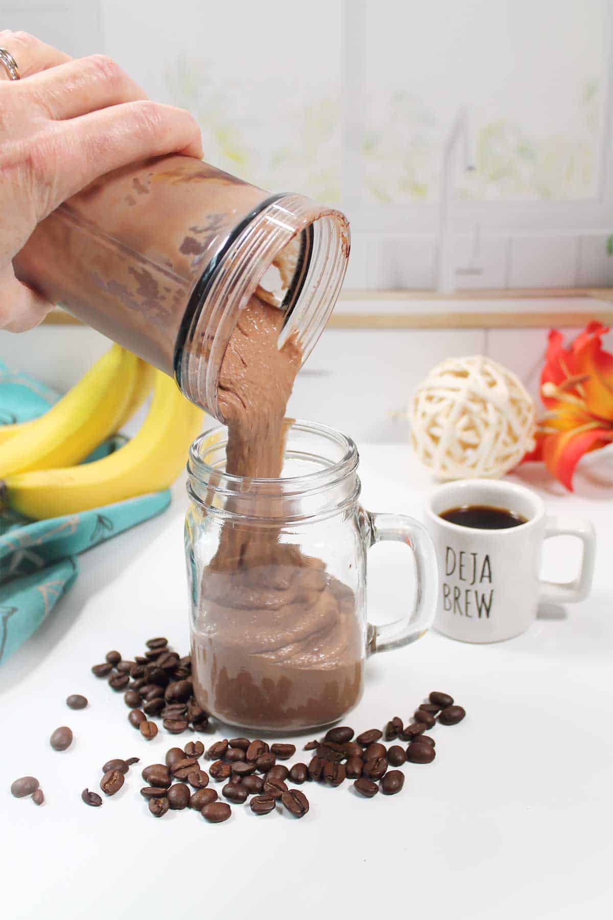 Pouring mocha smoothie into glass.