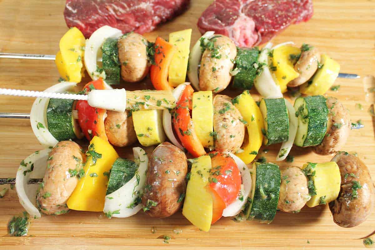 Brushing butter over skewered vegetables.