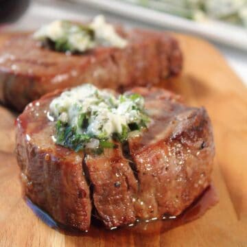 Closeup of grilled steak with herb butter.