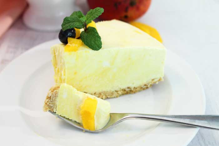 Mango Pineapple Icebox Cheesecake slice with bite
