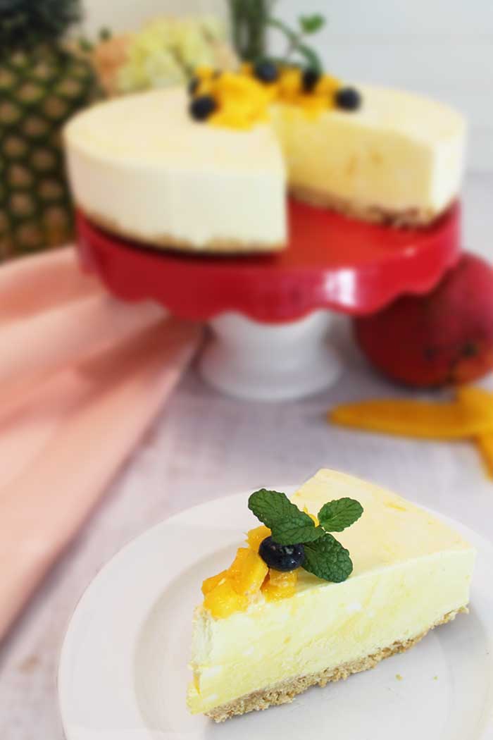 Slice of icebox cake on white plate with cake on cake stand in back.