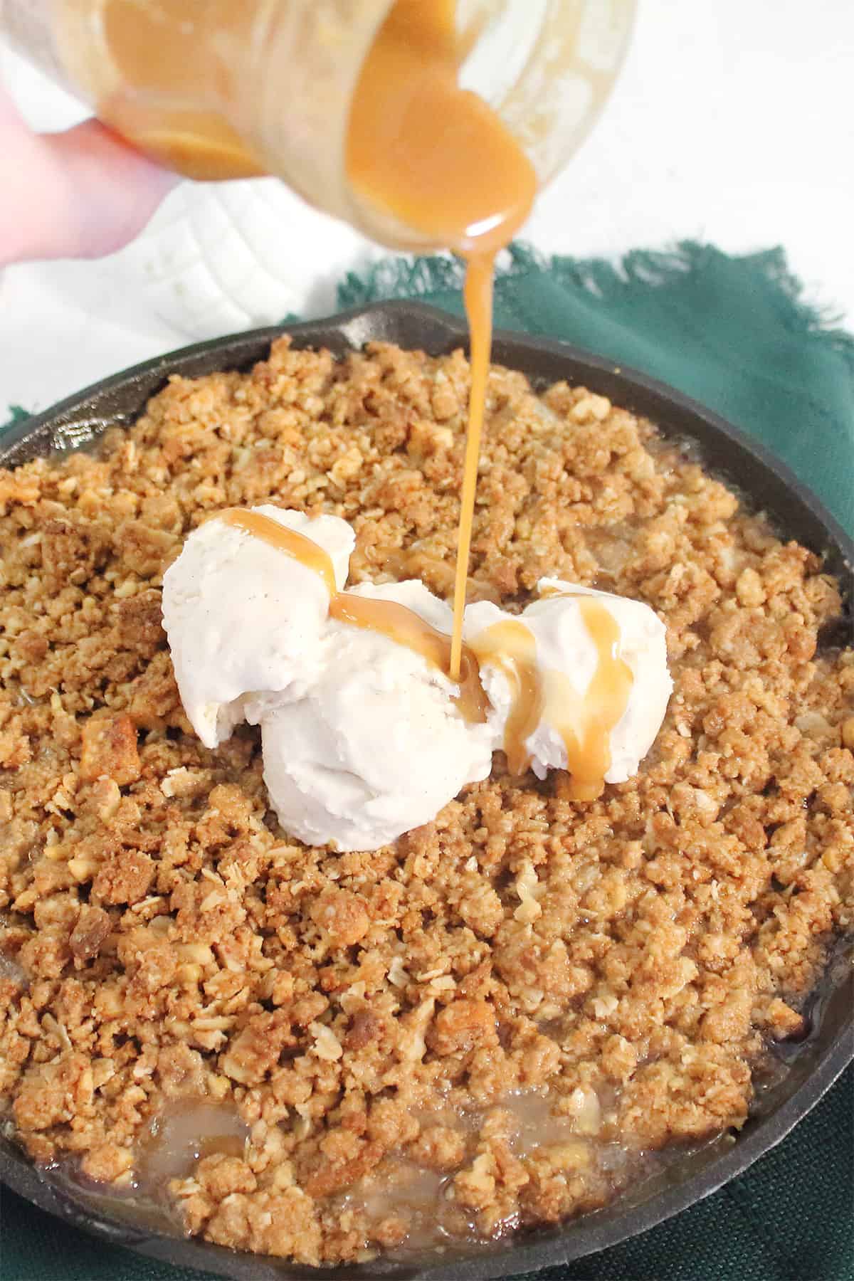 Drizzling caramel sauce over baked crumble.