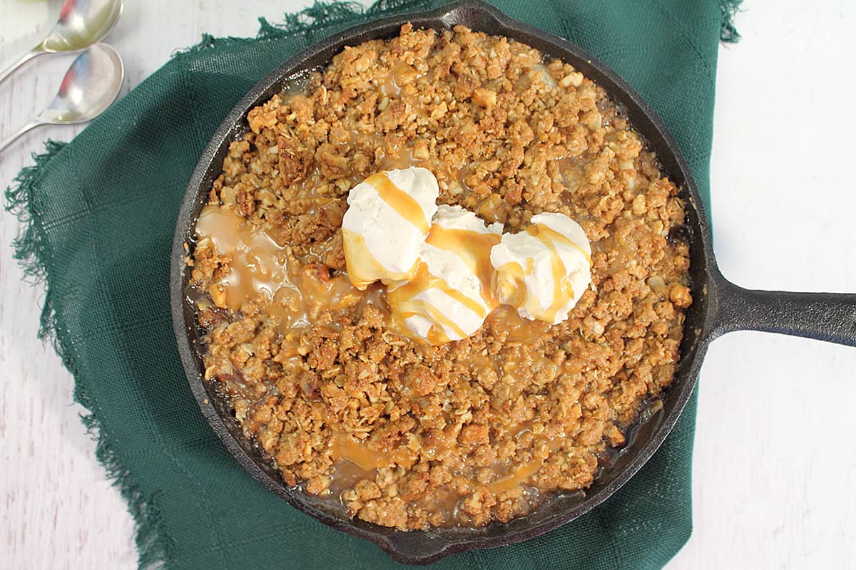 Overhead of baked crisp with ice cream and caramel drizzle.