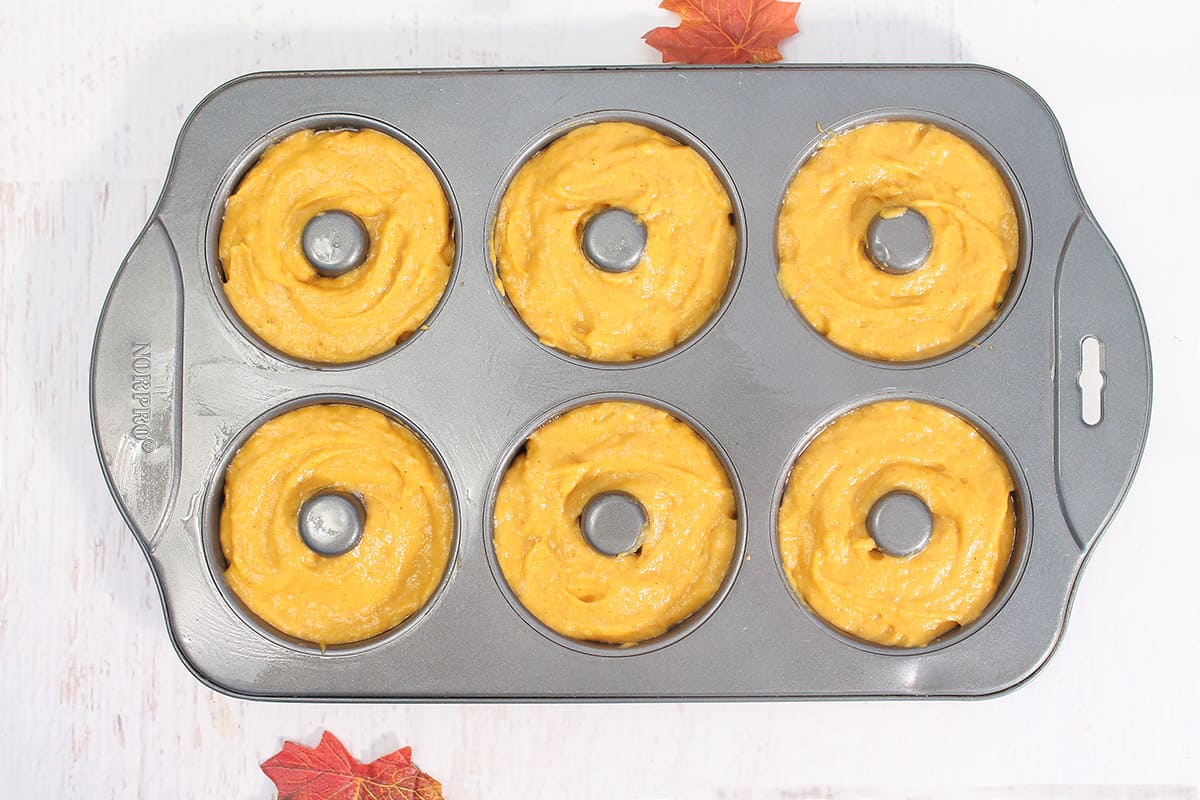 Overhead of donut batter in donut pan.