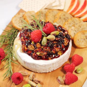 Air Fryer Brie topped with raspberry jam and pistachios.