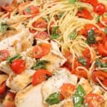 Closeup showing sliced chicken with bruschetta on top.