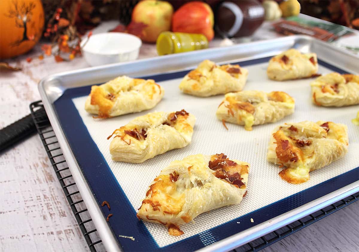 Baked puff pastry bites on cookie sheet.