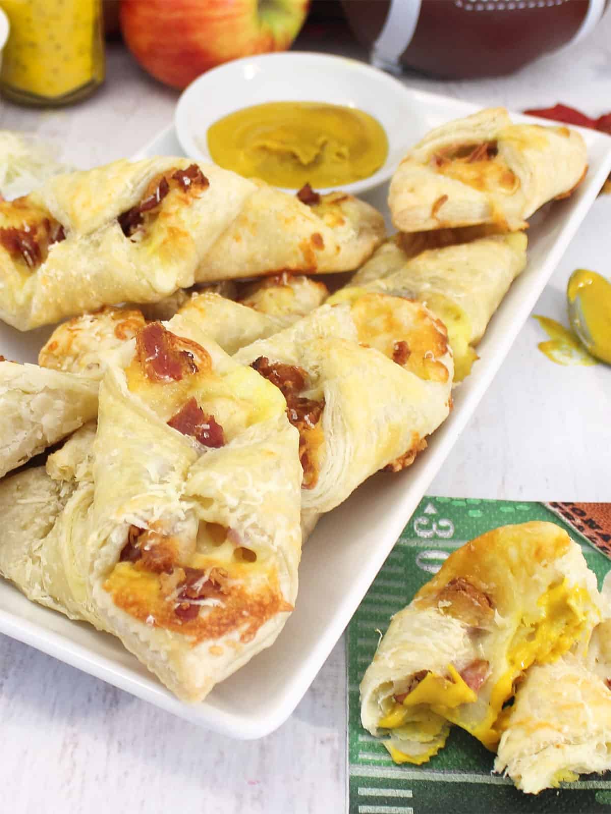 Plated puff pastry bites with a side of mustard.