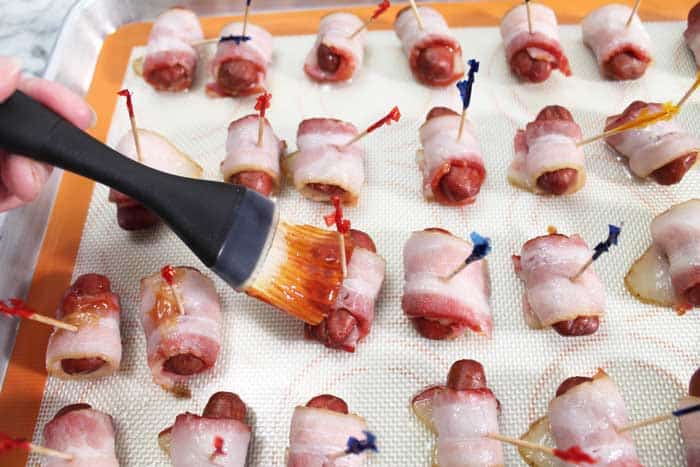 Brushing sauce on rolled smokies.