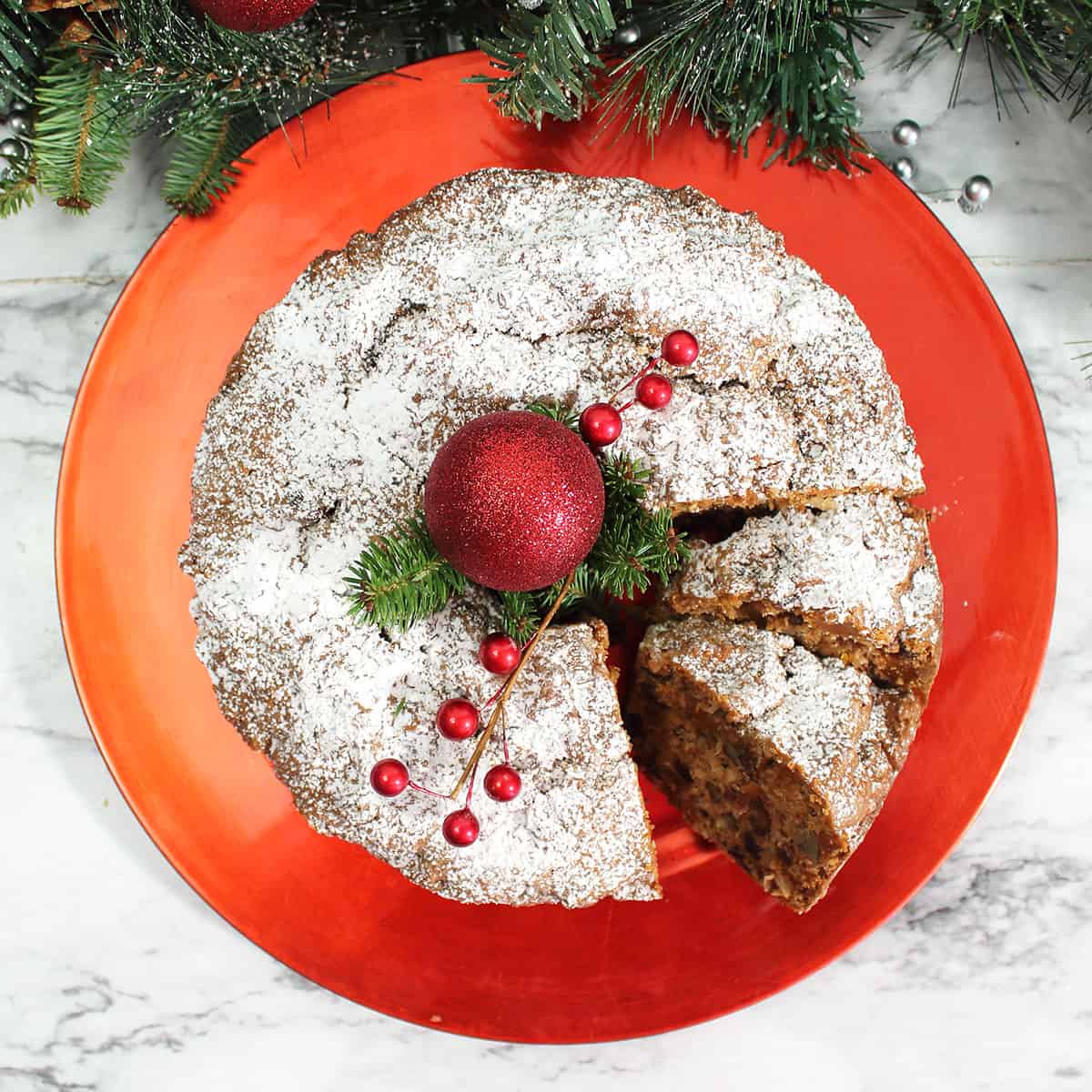 Overhead of sliced fruitcake with powdered sugar.