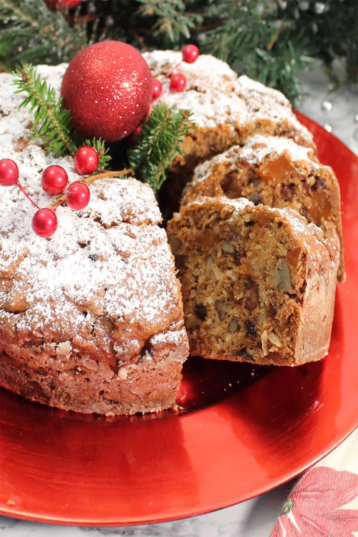 Sliced applesauce fruit cake on red platter.