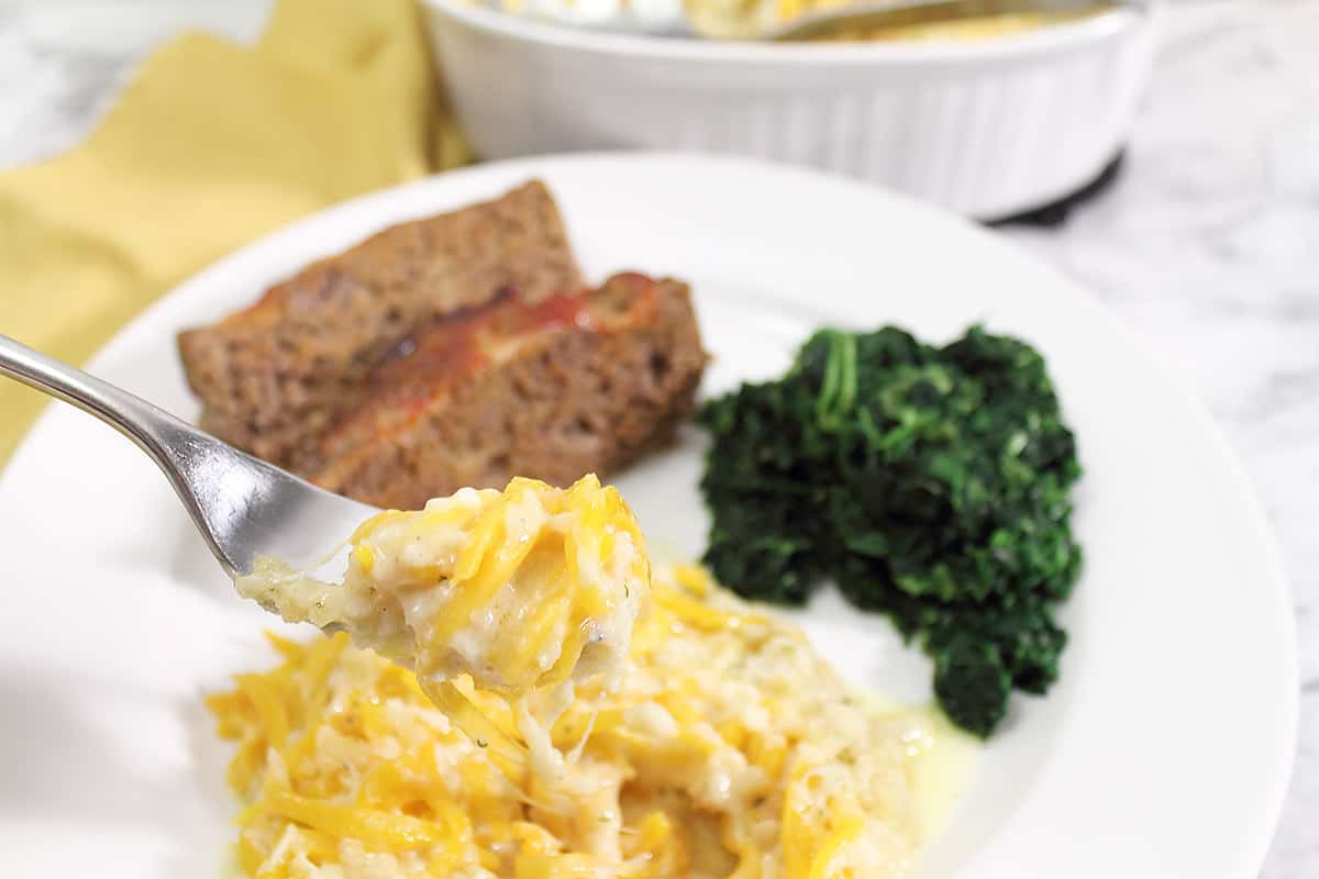 Plated squash bake with meatloaf and spinach.