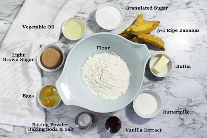 Ingredients laid out on white marble table to make muffins.
