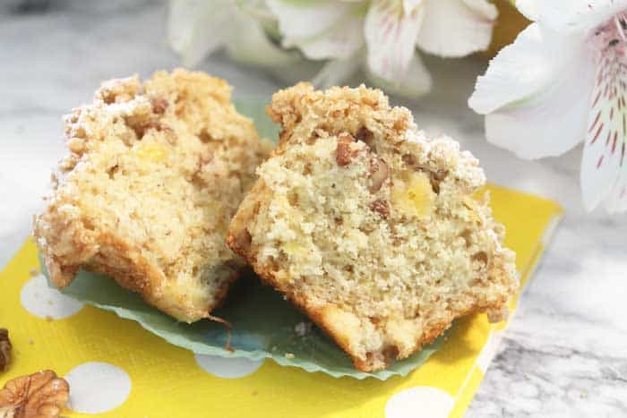 Muffin cut in half showing moist interior and dusted crumb topping.